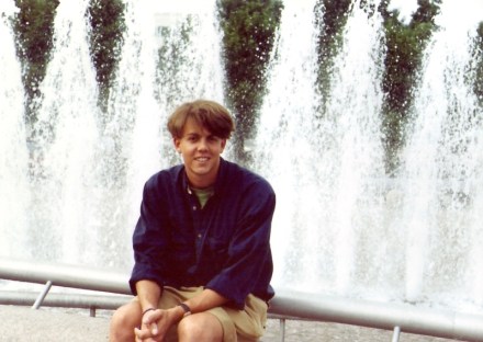 young man seated in front of fountain